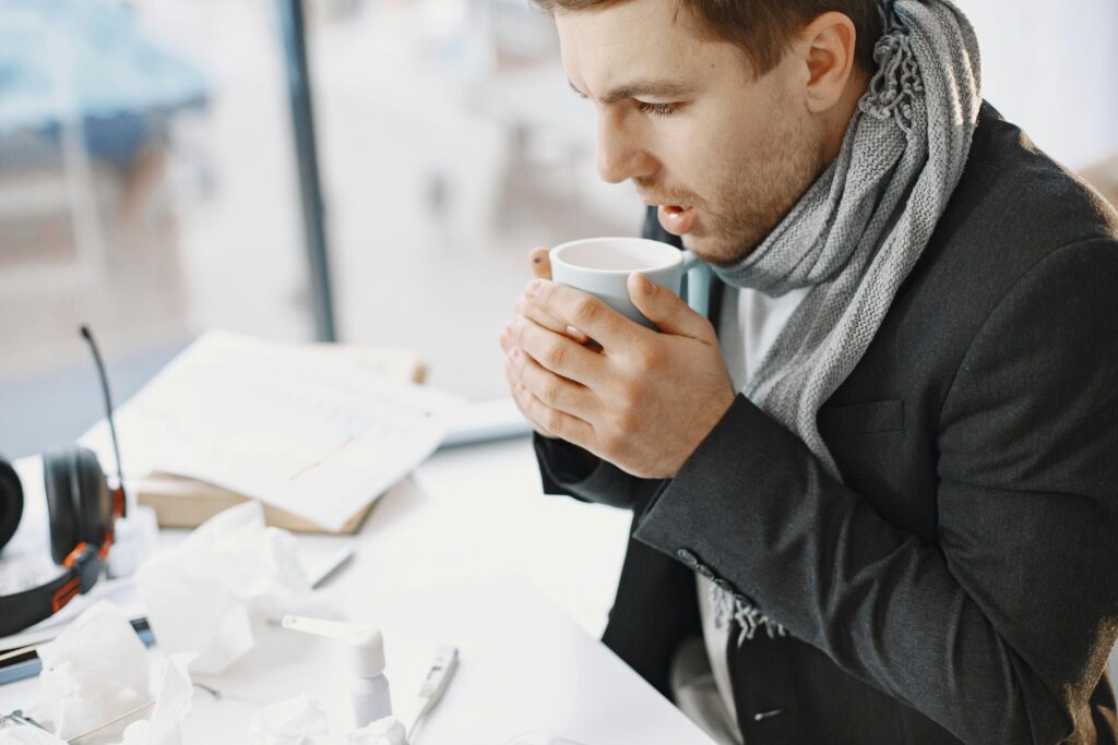 A man in black suit jacket holding a cup of coffee
