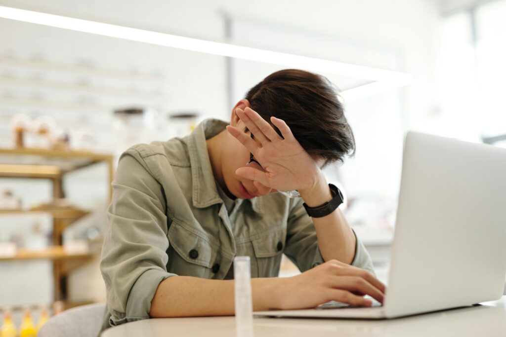 A man looking sick while working with his laptop