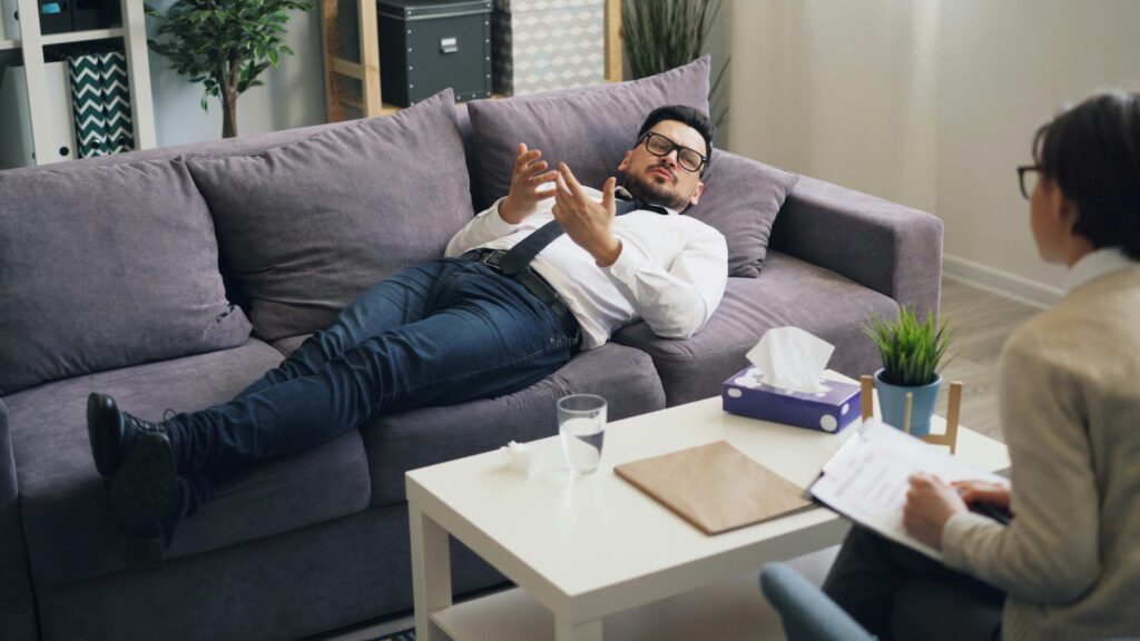 Modelling bad behaviour - A man is laying on a couch while talking to someone