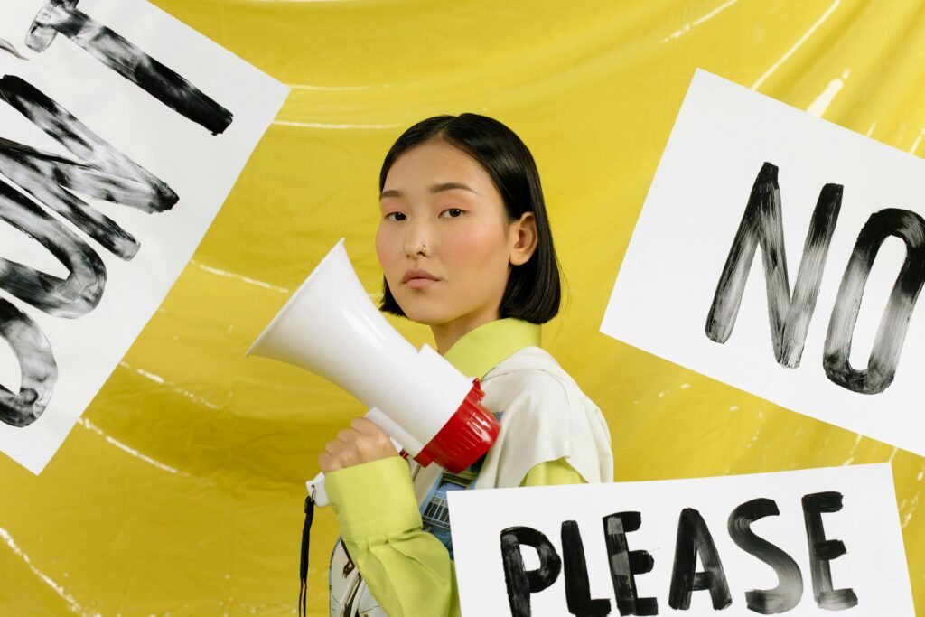 A confident leader standing calmly in a crowded office, with signs nearby including a clear ‘NO’ sign — symbolising focus, boundaries, and leadership clarity. Brand colours: yellow and black.