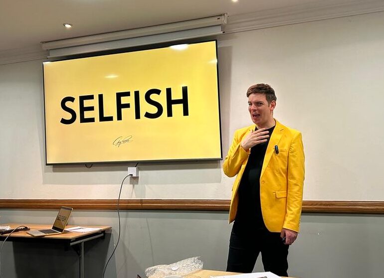 Selfish leadership workshop, with Gary wearing a yellow jacket at the front of the room